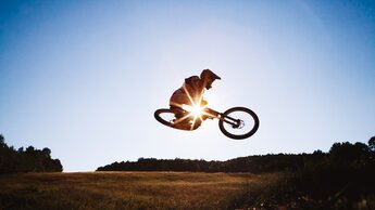 Ein Mann führt einen Mountainbike Stunt gegen den Himmel durch | © Freepik | EyeEm